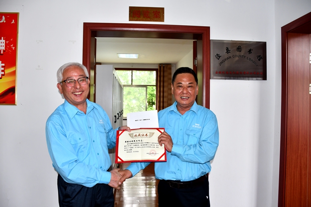 公司工会主席许锋（右）向公司监事会主席、捐书人胡夏生颁发《收藏证书》